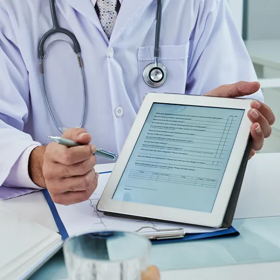 Doctor using an electronic tablet to make patient care notes